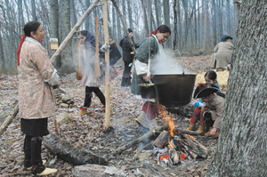 Native American re-enactors producing syrup in the way that the early Indiana settlers were taught.