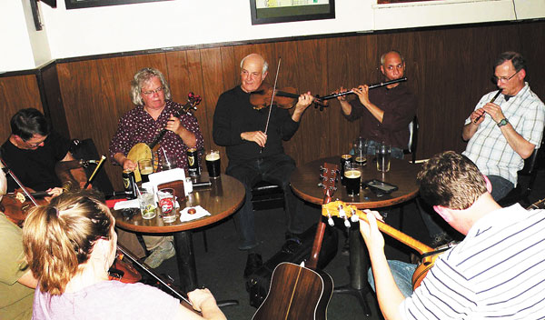 Photo by Paula Nicewanger/Weekly ViewThe tunes circle at the weekly Golden Ace Inn (2533 E. Washington St.) traditional Irish session, now in its fifteenth year. On Tuesday night May 19th, featured fiddler/guitarist Randal Bays,  noted recording artist and teacher, along with local traditional musicians provided some powerful music. (Clockwise) Randal Bays in the middle on fiddle, Dmitri Alano (flute), Mike Sweeney (whistle), Johnandrew Bellner (guitar, back to camera), Deb Shebish (fiddle, back to camera), Kate Smith (fiddle), Jim Smith (uilleann pipes) and Jenny Thompson (banjo). Stop by some Tuesday night at 8:30 p.m. to hear traditional Irish music.