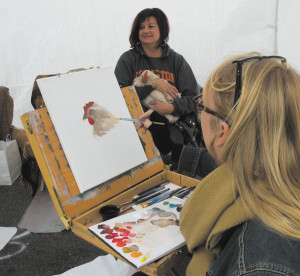 photo by Paula Nicewanger/Eastside VoiceRita Spalding painting a pet chicken portrait at the Halloween Street Fair -- you don't see that every day!