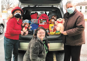 Ethel Winslow/Weekly ViewPaula Nicewanger (L) and Judy Crawford (R) helped load Jan DeFerbrache's (center) vehicle with donated toys and goods for Gaia Works to give to Coburn Place families, and to help stuff baskets of goodies for needy families for the holidays.